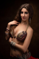 Portrait of a young woman in oriental costume. Belly dance. Oriental dance. The brunette.