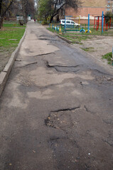 Poor condition of the road surface. Winter season. Hole in the asphalt, risk of movement by car, bad asphalt, dangerous road, potholes in asphalt. Kiev,Ukraine