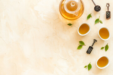 Teapot and cups with green tea, top view. Flat lay of tea ceremony concept.