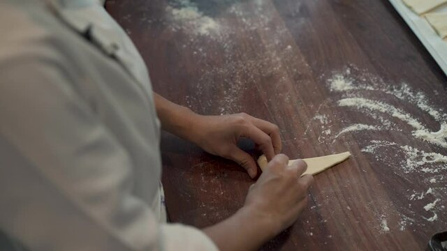 Woman hands rolling croissant.A demonstration video of pastry chefs rolling croissant dough