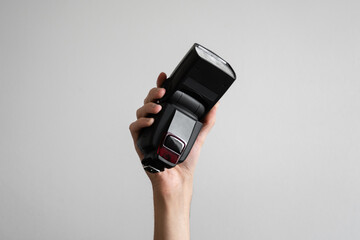 Fototapeta premium Hand holding a hand flash in the air on a white background