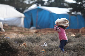 Syrian refugee little girl took bread from charity to tent