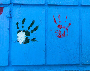 Colorful bright prints of children's hands on the blue wall, World Children's Day on June 1 and child protection.