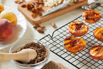 Grilled peaches summer dessert American bbq. Served with almonds, ice cream and cookie crumbs. close up