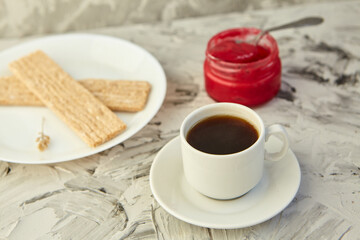 Crispbread with jam for Breakfast on a gray background. A jar of Fresh Honey with foam is next to a Cup of coffee. A minimum of calories. proper nutrition