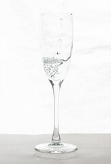 Filling up the champagne glass water  isolated on a white background