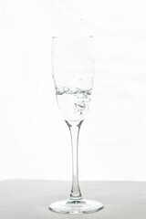 Filling up the champagne glass water  isolated on a white background
