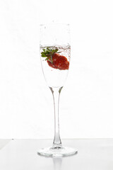 Filling up the champagne glass with strawberry isolated on a white background copy space