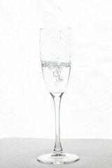 Filling up the champagne glass water  isolated on a white background