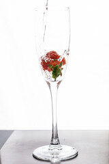 Filling up the champagne glass with strawberry isolated on a white background copy space