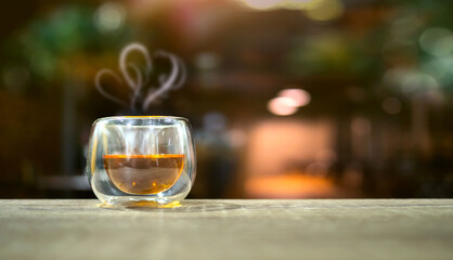 Vintage Hot Coffee Cup on Wood Table in blurred Coffee Shop background.