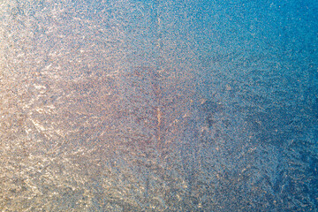 Frozen surface with icy pattern on window glass in cold winter day