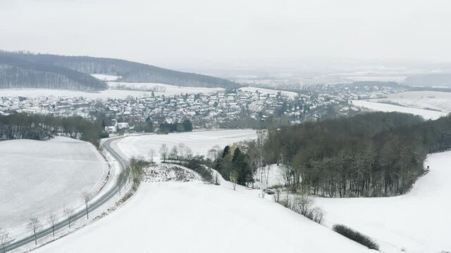 Drone aerial of the fairy tale castle Plesse in winter with a huge amount of snow on a beautiful mountain near Bovenden, Germany, Europe.