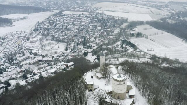 Drone aerial of the fairy tale castle Plesse in winter with a huge amount of snow on a beautiful mountain near Bovenden, Germany, Europe.