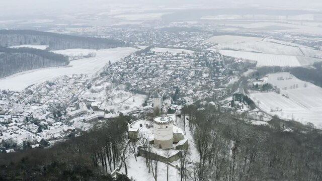 Drone aerial of the fairy tale castle Plesse in winter with a huge amount of snow on a beautiful mountain near Bovenden, Germany, Europe.