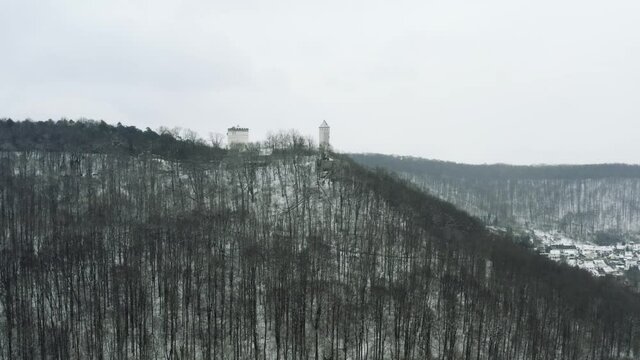 Drone Aerial of the fairy tale castle Plesse in winter with a huge amount of snow on a beautiful mountain near Bovenden, Germany, Europe.