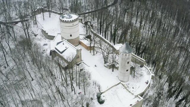 Drone aerial of the fairy tale castle Plesse in winter with a huge amount of snow on a beautiful mountain near Bovenden, Germany, Europe.