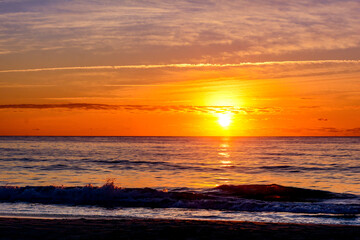 Beach sunrise over waves with clouds, Garden City Beach, South Carolina