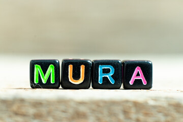 Black color block with word mura on wood background