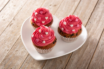 Cupcakes decorated with sugar hearts for Valentine's Day on wooden table	