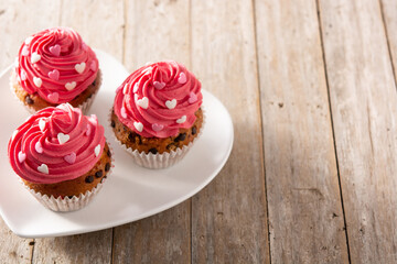 Cupcakes decorated with sugar hearts for Valentine's Day on wooden table. Copy space	