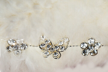 sparkling silver jewelry on white fluffy fur close up