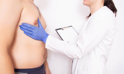 Plastic surgeon doctor examines the male breast before surgery. Male gynecomastia concept,...