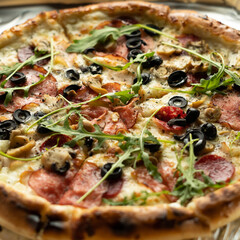 Close-up of pizza with olives, salami and cheese in a box. Delivery of orders from an Italian pizzeria.