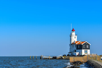 Fototapeta na wymiar Marken, Netherlands - April 20, 2019: Lighthouse sea rock landscape. Lighthouse scene. Lighthouse view. The Horse Of Marken Lighthouse..