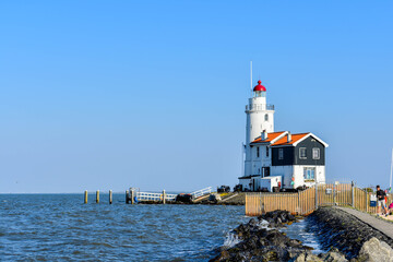 Marken, Netherlands  - April 20, 2019: Lighthouse sea rock landscape. Lighthouse scene. Lighthouse view. The Horse Of Marken Lighthouse..