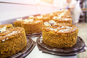A lot of chocolate sponge cakes with condensed milk and prunes in the confectionery industry, making. Food industry, torte