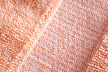 Soft peach-colored fleecy fabric. Orange fabric background, macro