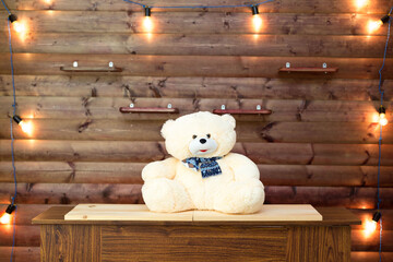 Soft toy bear on wood background. Incandescent lamp light