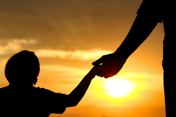 happy dad with a child in the park outdoors silhouette
