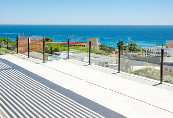 Sea view from a large terrace with a glass partition.