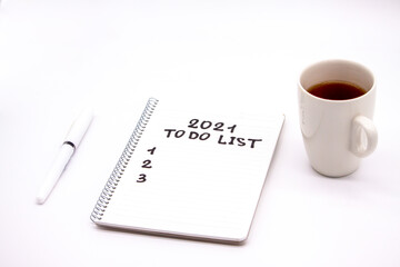 Notepad inscripted 2021 to do list with a pen on a white background close up