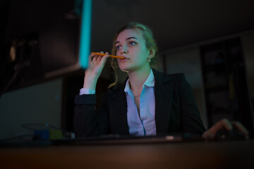 Young business woman office worker sitting near PC working at late night