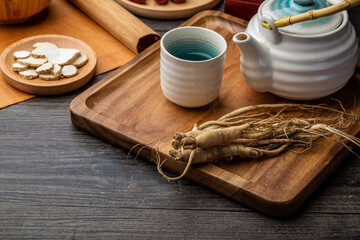 Obraz na płótnie Canvas Ginseng and tea cup are on the table