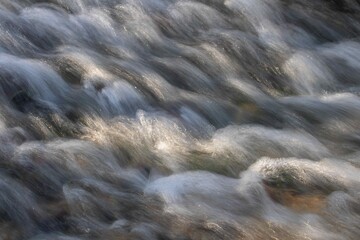 flowing water, movement over the stones in the river