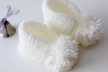 Obraz na płótnie Canvas hand knitted white wool baby shoes