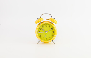 Yellow Alarm Clock With White Background. Selective focus.