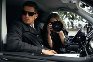 Private detectives with modern camera spying from car - obrazy, fototapety, plakaty