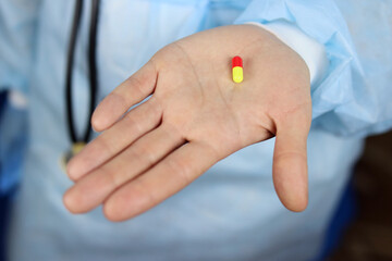 Colored capsule tablet in the hand of a doctor or nurse