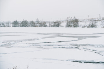 Winter frosty landscape of the river with broken ice