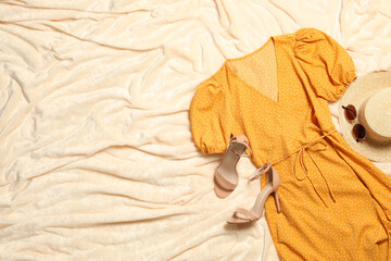 Flat lay composition with stylish yellow dress on beige blanket. Space for text