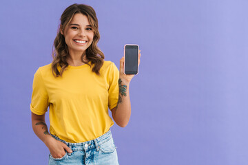 Smiling young woman showing blank screen smartphone