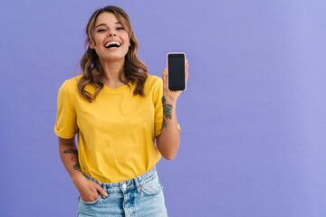 Smiling young woman showing blank screen smartphone