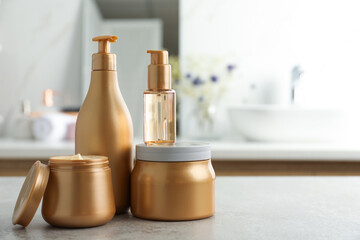 Different hair care products on table in bathroom, space for text