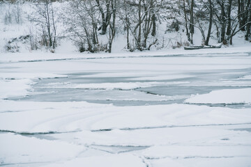 Winter frosty landscape of the river with broken ice