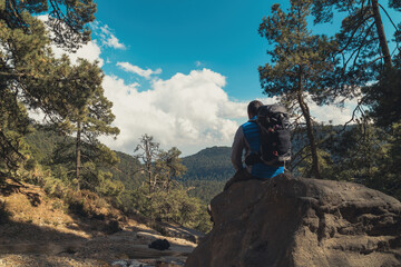 Male hiker with a backpack sitting on a rock on the Iztaccihuatl Mountain in Mexico